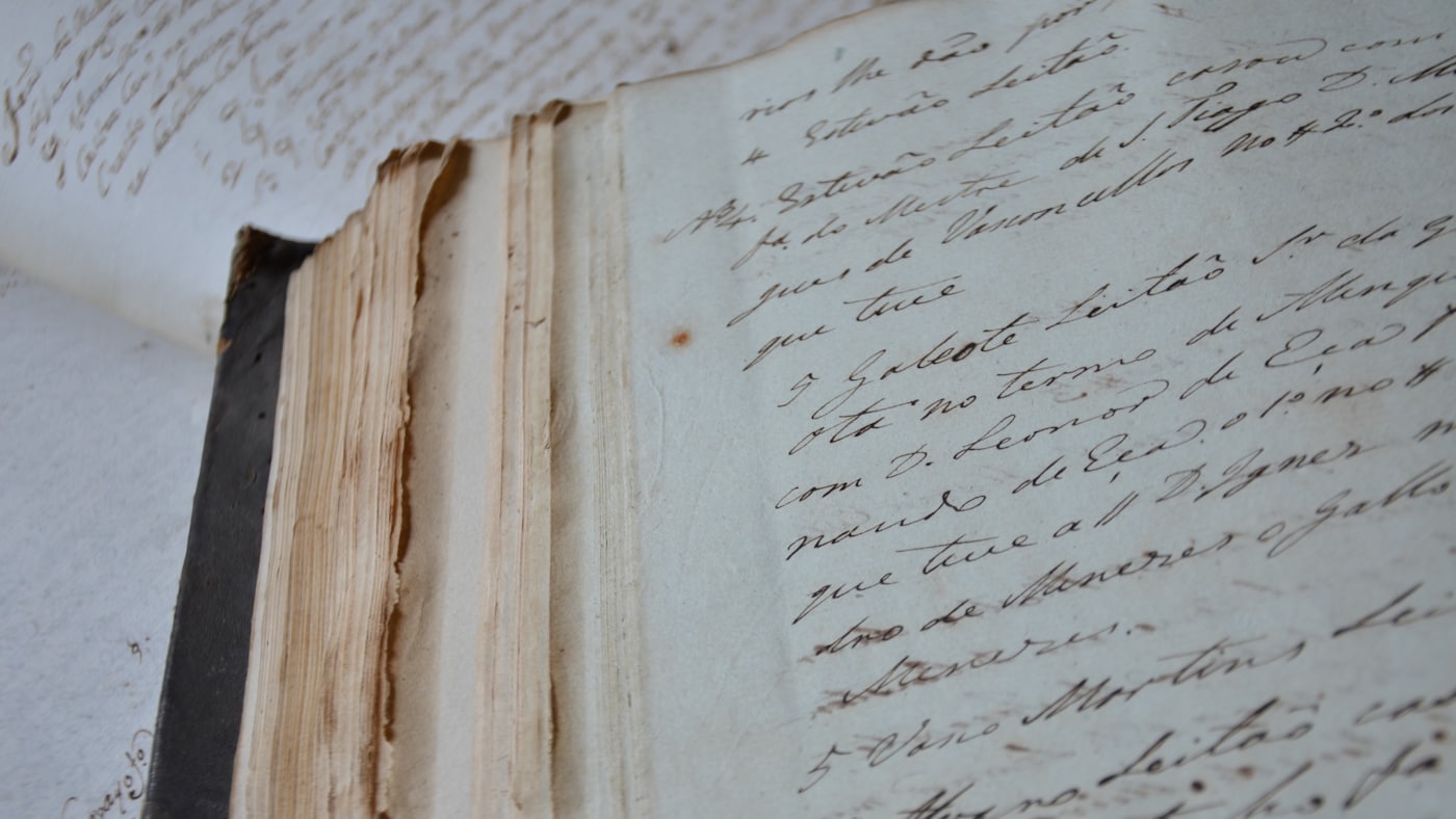 Pagini vechi scrise de mână, cu cerneală maro, într-un registru legat.